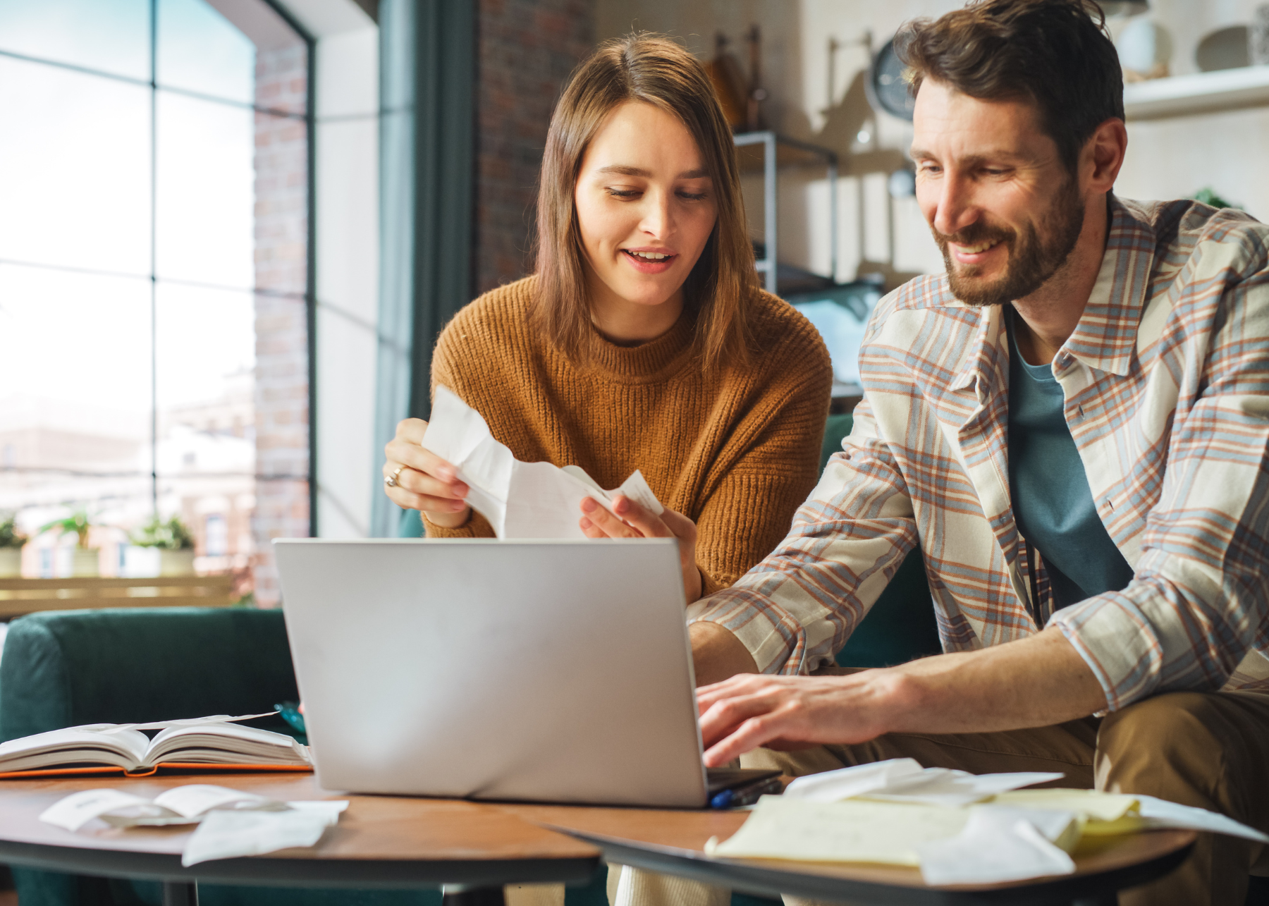 Smiling couple using a laptop together at a table