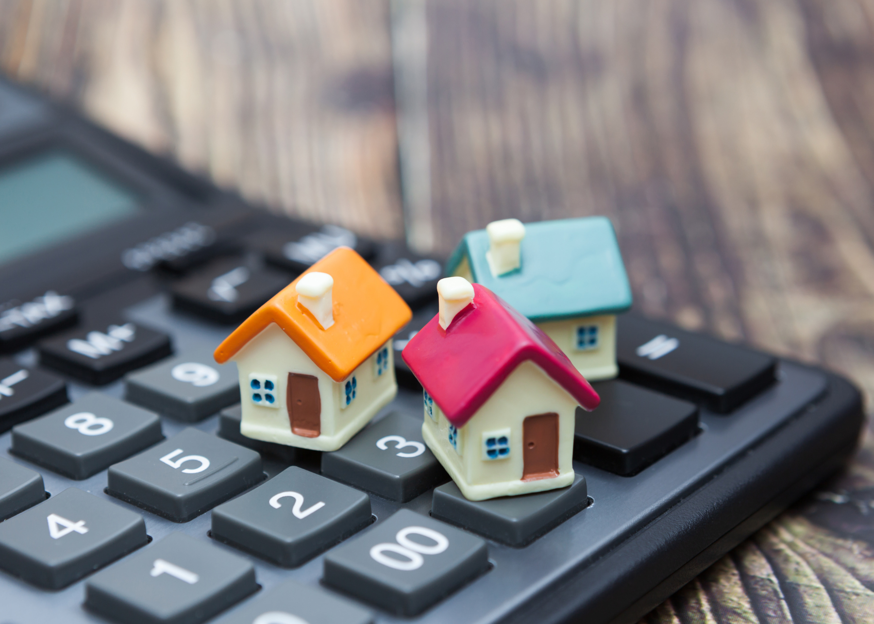 Three small houses on calculator close up