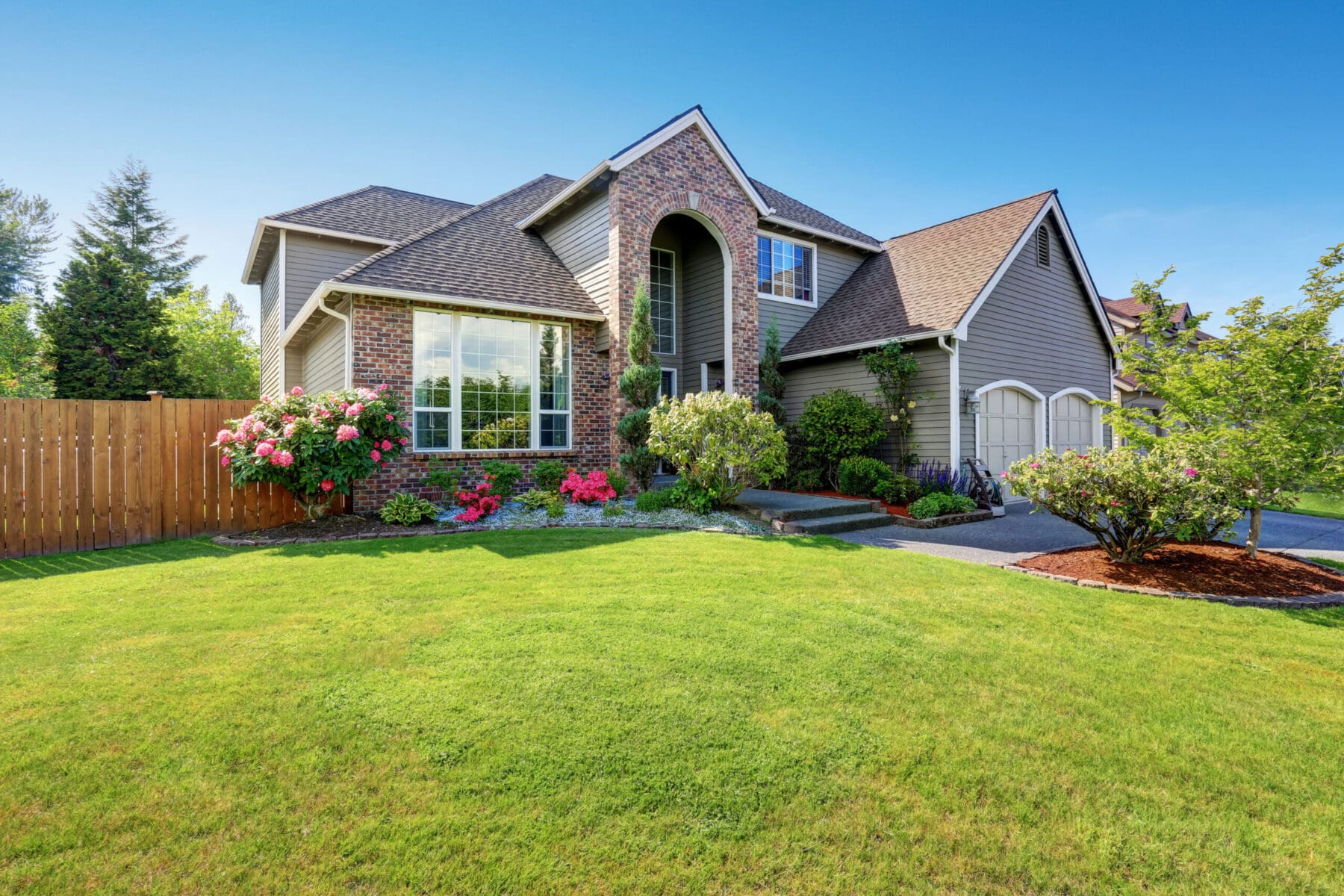 Big house with exterior of brick and siding trim and double garage.